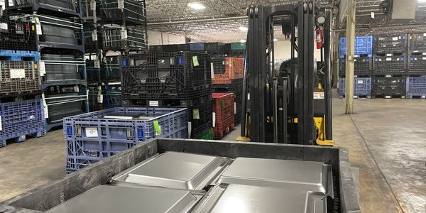 Forklift with stacked crates and metal parts
